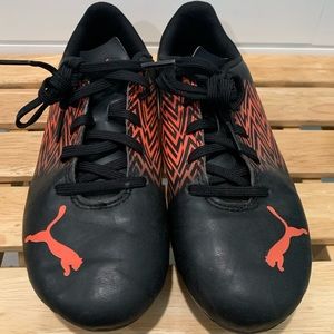 Black and orange Puma soccer cleats.